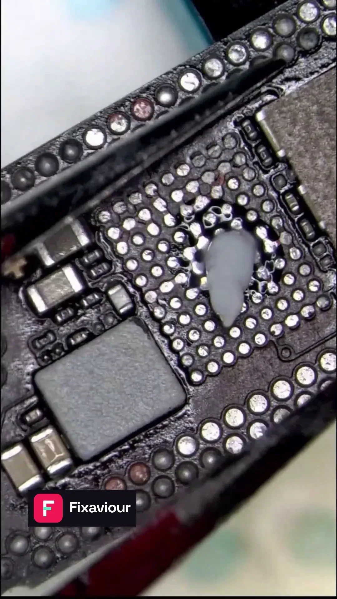 Microscope frame showing exposed pads during iPhone 15 Pro Max charging-board work