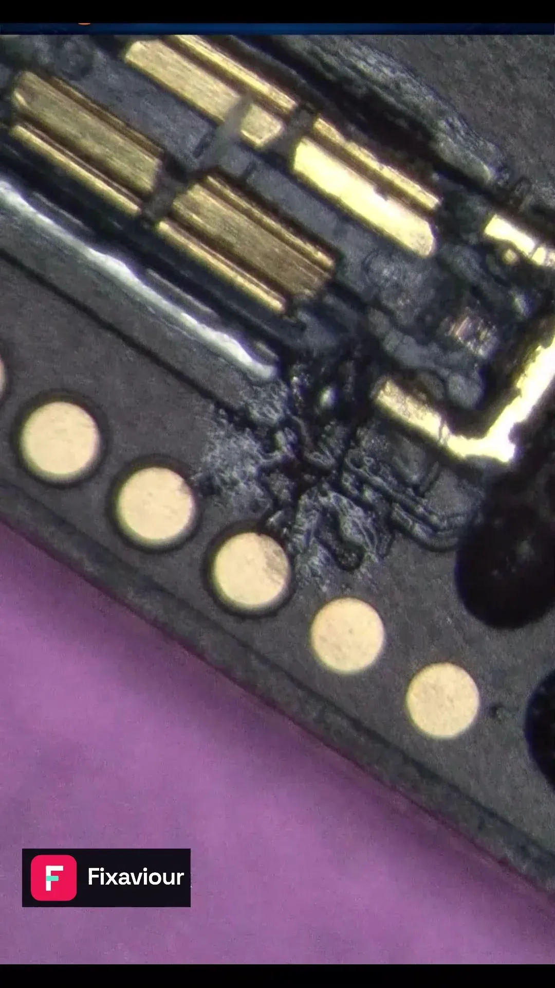 Microscope view of the battery-connector contact area during an iPhone 16 repair
